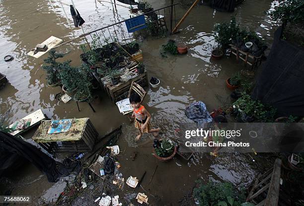 Girls play at a store inundated by floodwaters on the shores of the Yangtze River July 26, 2007 in Wuhan of Hubei Province, central China. Wuhan is...