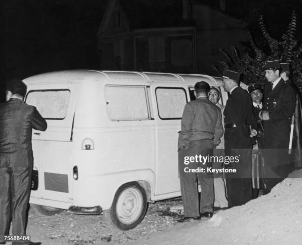 In the Paris suburb of Le Petit-Clamart, police examine a yellow Renault Estafette van with painted-out windows, used earlier in the day in an...