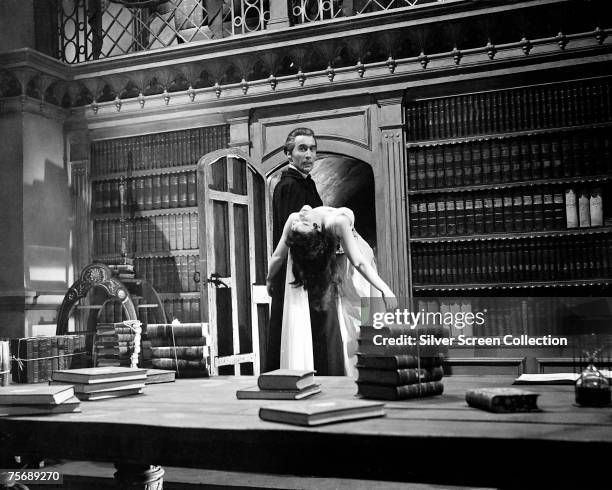 British actor Christopher Lee carries actress Valerie Gaunt from the library in a scene from the Hammer classic 'Dracula', aka 'The Horror of...