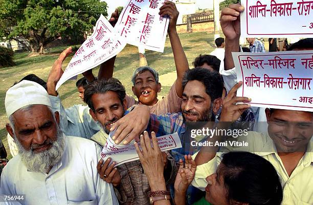 About 50 to100 supporters hold posters which read "we dont need temple or mosque, we need peace and work" at a peace rally March 10, 2002 in front of...