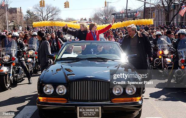 Olympic figure skating gold medalist Sarah Hughes and her coach Robin Wagner wave to people at a parade in Hughe's honor March 10, 2002 as they are...