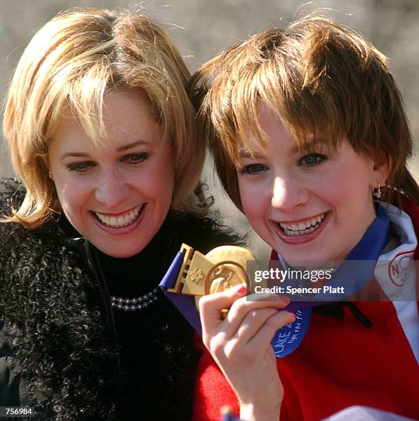 Olympic figure skating gold medalist Sarah Hughes displays her gold medal with her coach Robin Wagner at a parade in Hughes'' honor March 10, 2002 as...