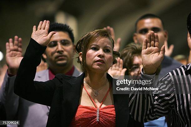 Immigrants are sworn in as U.S. Citizens during naturalization ceremonies on July 26, 2007 in Pomona, California. Some of 6,000 people taking their...