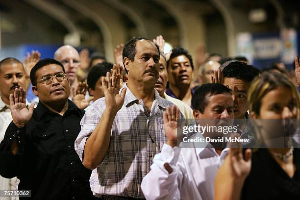 Immigrants are sworn in as US citizens during naturalization ceremonies on July 26, 2007 in Pomona, California. Some of the 6,000 people taking their...