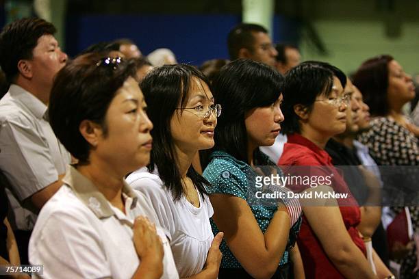 Immigrants say the Pledge of Allegiance after being sworn in as US citizens during naturalization ceremonies on July 26, 2007 in Pomona, California....
