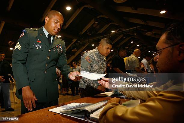Members of the US military receive their citizenship certificates after being sworn in as US citizens during naturalization ceremonies on July 26,...