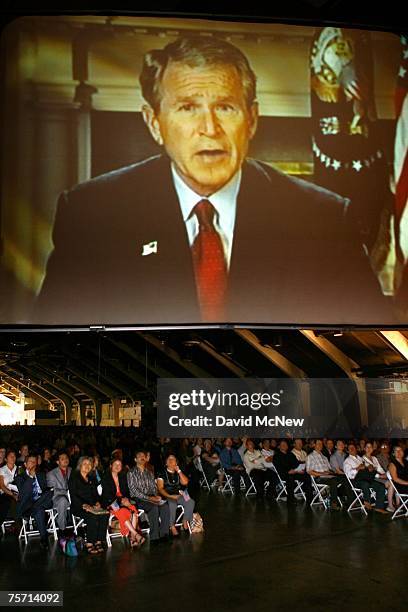 Immigrants watch a video presentation of a welcome message by President Bush after being sworn in as a US citizen during naturalization ceremonies on...