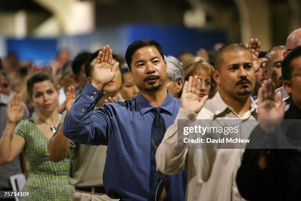 Immigrants are sworn in as US citizens during naturalization ceremonies on July 26, 2007 in Pomona, California. The 6,000 people taking their...