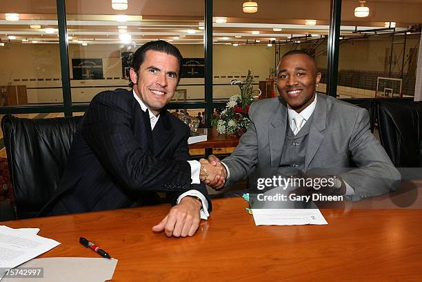 Milwaukee Bucks general manager Larry Harris and guard Maurice Williams pose for a photograph after William's free agent signing with the Bucks on...