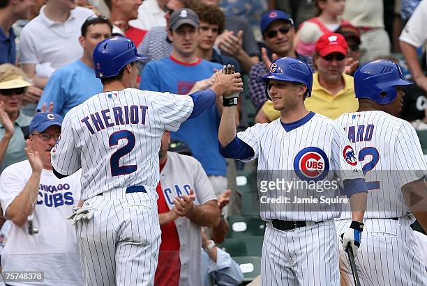 Ryan Theriot and Mike Fontenot of the Chicago Cubs celebrate after Theriot scored a run against the San Francisco Giants at Wrigley Field on July 19,...