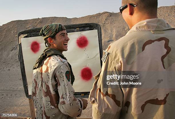 An Iraqi Army scout laughs with a U.S. Navy SEAL after seeing his results during target practice July 26, 2007 in Fallujah, Iraq. The SEALS are...