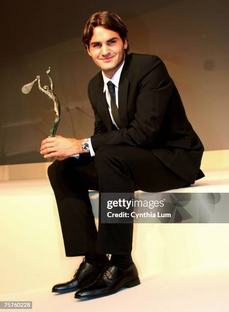 Roger Federer pose's with the Mens Champion's award that was presented to him at the International Tennis Federation, World Champions Dinner, held at...