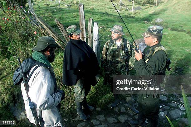 Members of the Revolutionary Armed Forces of Colombia listen to news from other FARC locations operating in the region April 7, 2002 in Cundinamarca,...