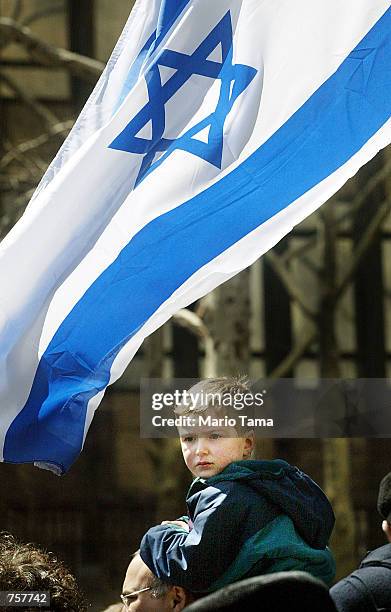 Nadav Neuman sits atop his father Ron's shoulders beneath an Israeli flag during a rally at Dag Hammarskjold Plaza in support of Israel April 7, 2002...