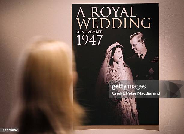 Worker looks at a poster of the 'Royal Wedding: 20 Novermber 1957 exhibition' at Buckingham Palace on July 27, 2007 in London. Queen Elizabeth II...