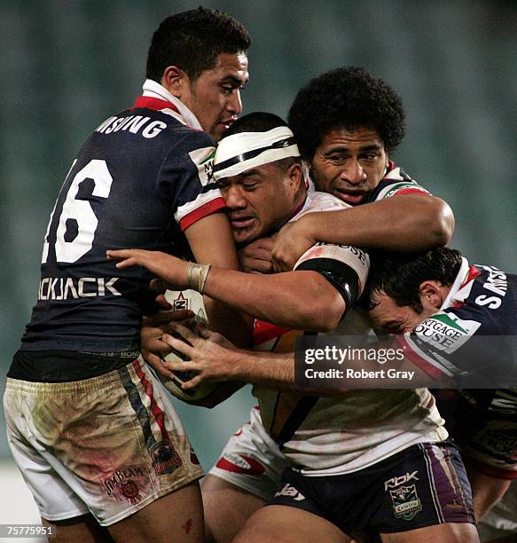 Jeff Lima of the Storm is tackled by Setaimata Sa and Lopini Paea of the Roosters during the round 20 NRL match between the Sydney Roosters and the...