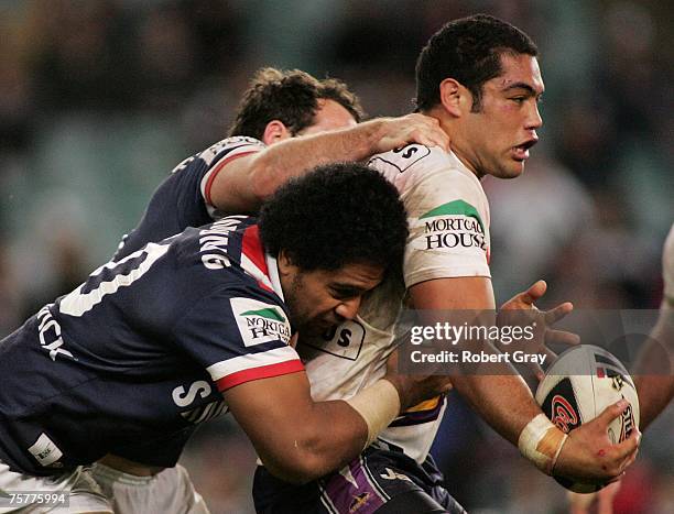 Adam Blair of the Storm is tackled by Lopini Paea of the Roosters during the round 20 NRL match between the Sydney Roosters and the Melbourne Storm...