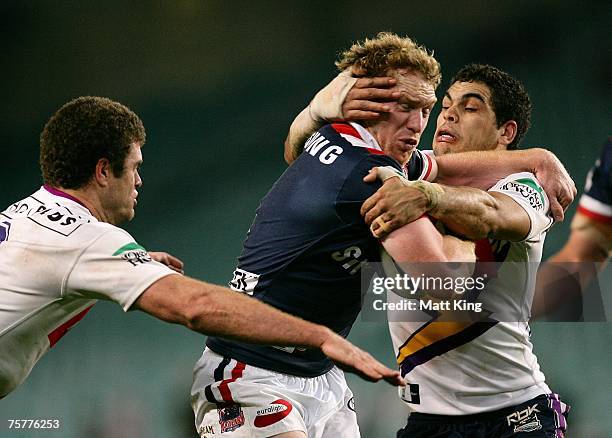 Joel Monaghan of the Roosters is tackled by Greg Inglis of the Storm during the round 20 NRL match between the Sydney Roosters and the Melbourne...