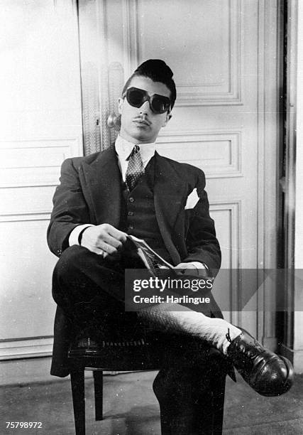 Man with a thin moustache and a quiff hairdo wearing a zoot style outfit in Paris, 1944.