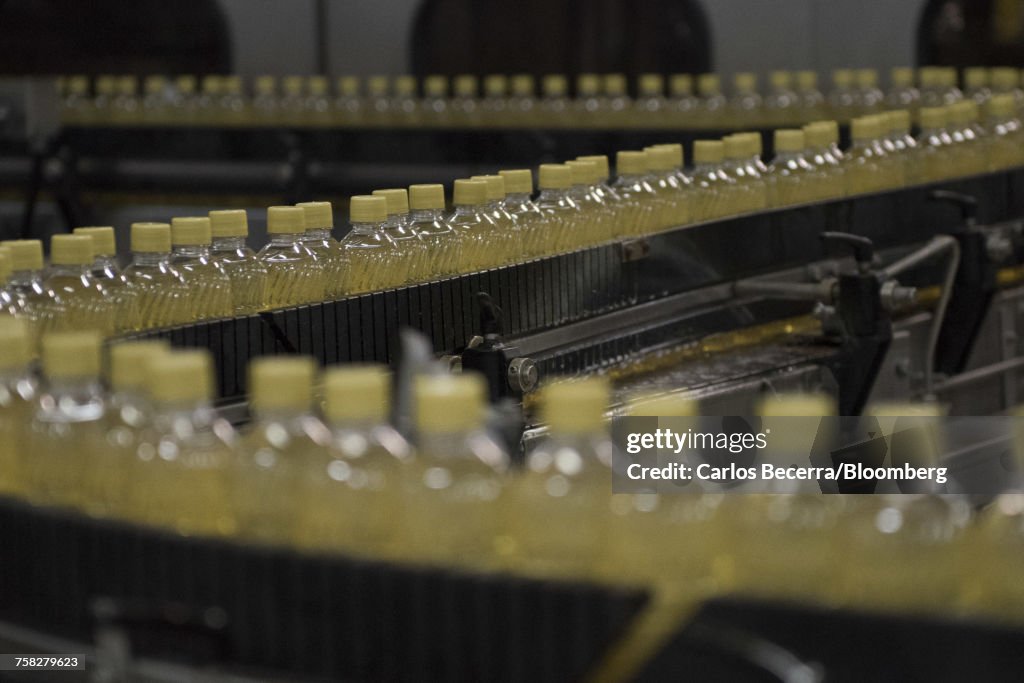 Bottles of corn oil move along a conveyor belt