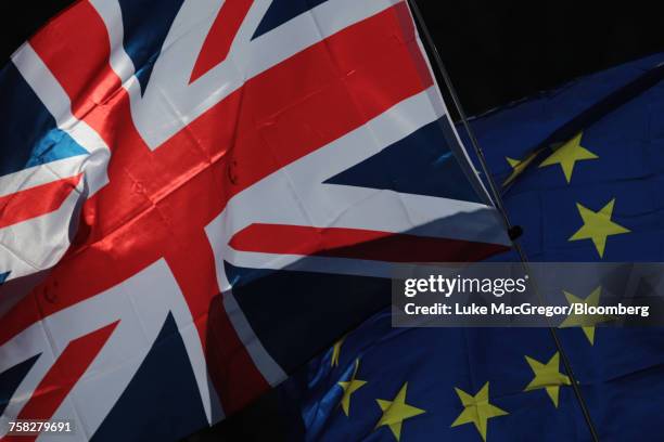 a union flag, also known as union jack, left, and a european union (eu) flag - british and eu flag foto e immagini stock