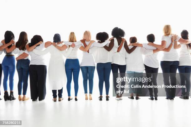 rear view of diverse women standing in a row hugging - femmes de dos enlacée photos et images de collection
