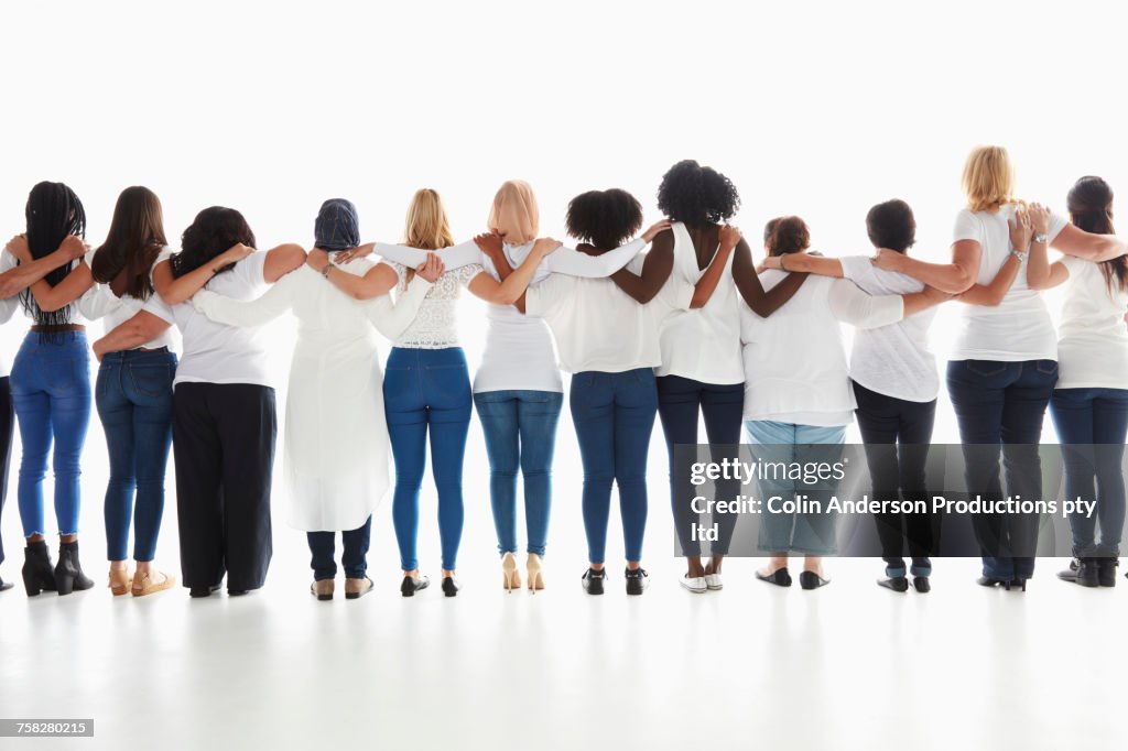 Rear view of diverse women standing in a row hugging