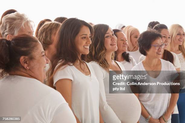 diverse women standing and smiling - hispanic man profile hopeful stock-fotos und bilder