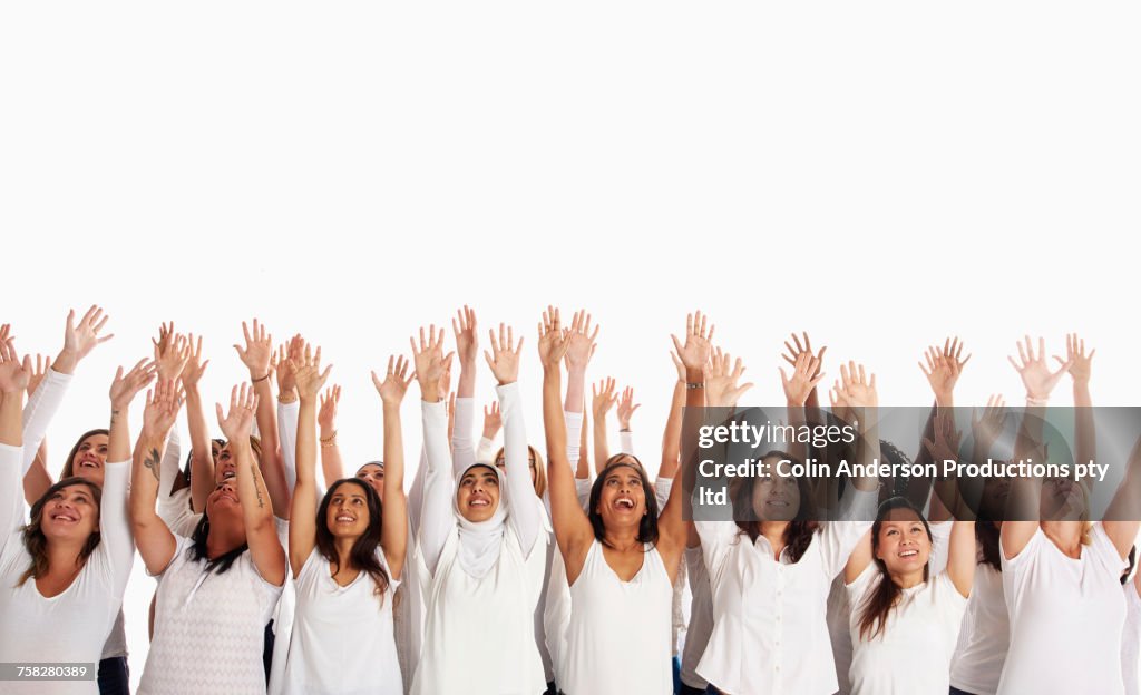 Crowd of diverse women celebrating with arms raised