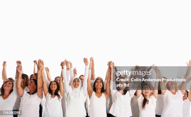 crowd of diverse women holding hands with arms raised - arab old woman stock-fotos und bilder