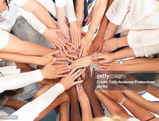 hand of diverse women huddling - partie-médiane photos et images de collection