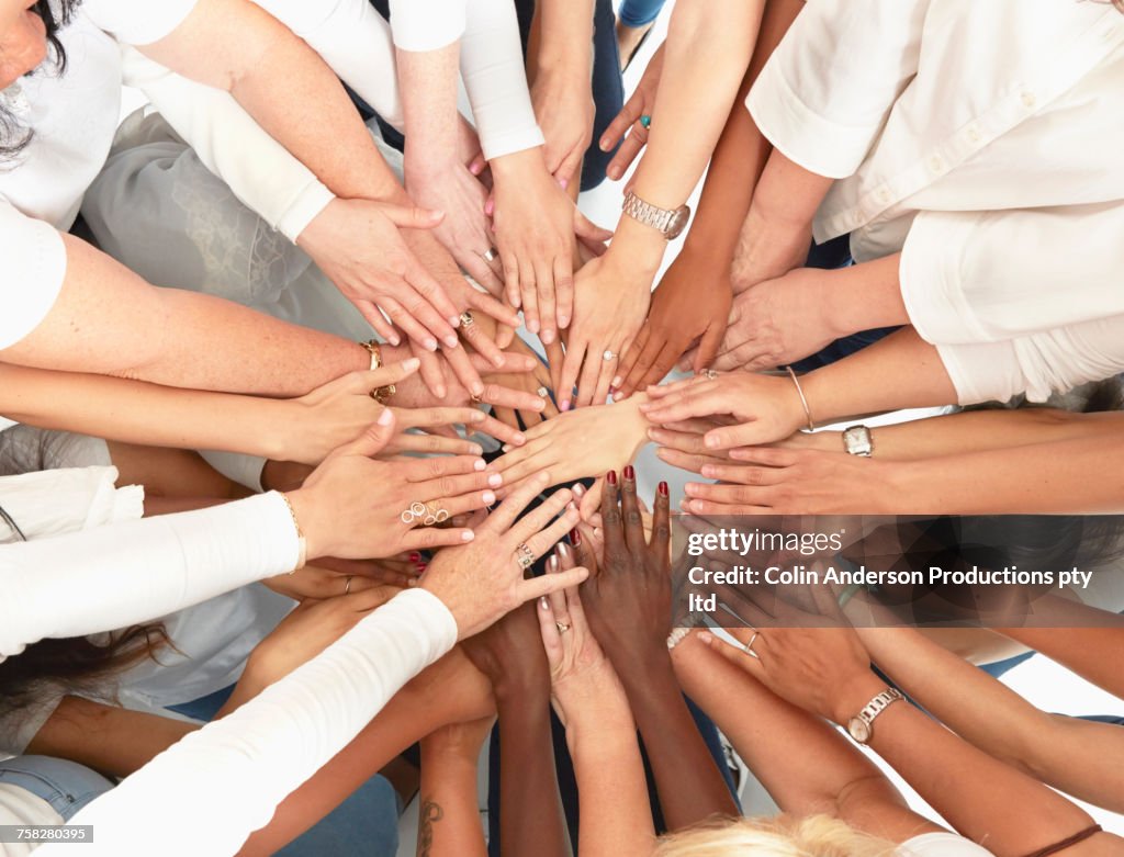 Hand of diverse women huddling