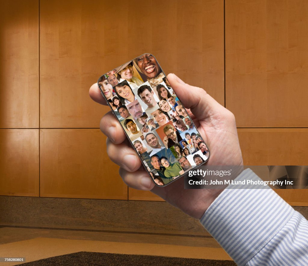 Hand of businessman holding social media cell phone in office