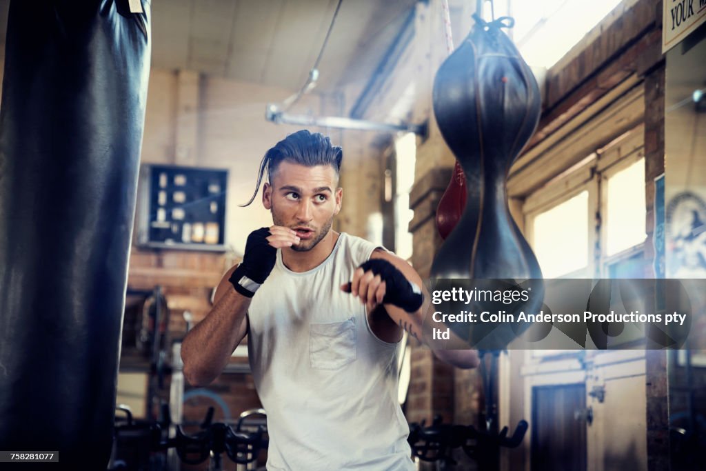 Hispanic Man Punching Speed Bag In Gymnasium High-Res Stock Photo ...