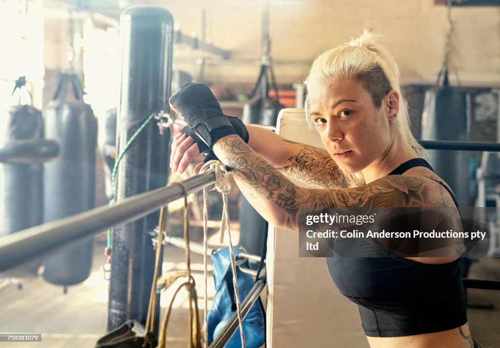 Caucasian woman resting in boxing ring
