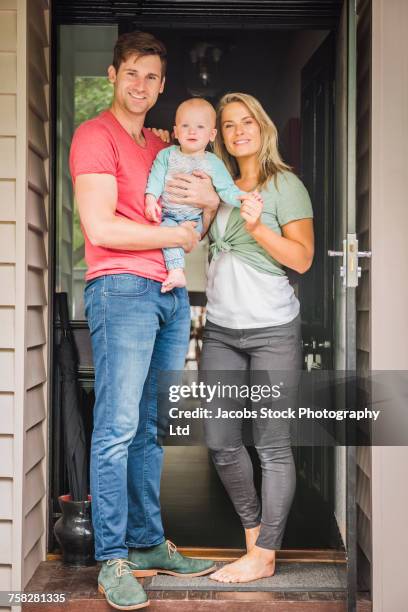 portrait of caucasian couple with baby son in doorway - melbourne homes stock pictures, royalty-free photos & images