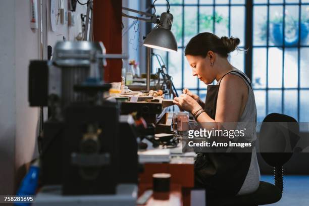 female jeweller at work in jewellery workshop - jeweller stock pictures, royalty-free photos & images