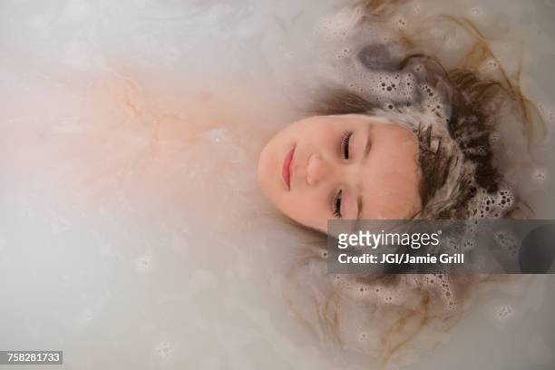face of caucasian girl floating in bubble bath - schaumbad stock-fotos und bilder