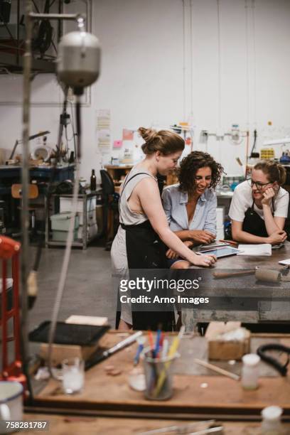 three female jewellers looking at digital tablet at workbench meeting - the 2017 makers conference stock pictures, royalty-free photos & images