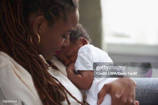 black mother holding sleeping baby son - black mother and baby stock pictures, royalty-free photos & images