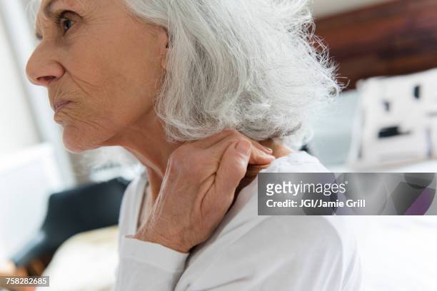 older woman rubbing the neck - gray hair stress stock pictures, royalty-free photos & images