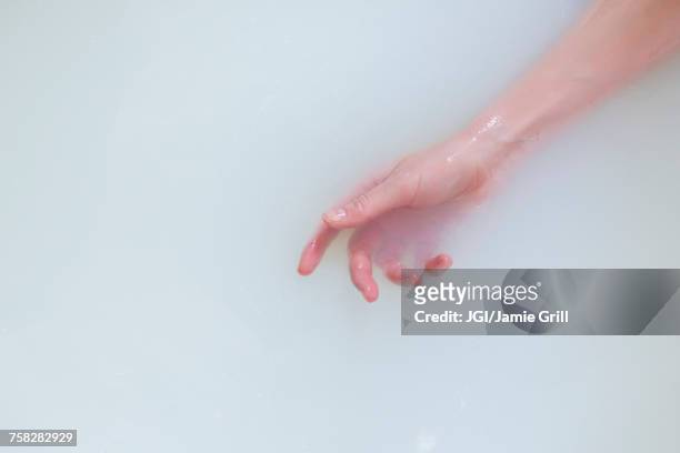 hand of caucasian woman in the milk bath - milchbad stock-fotos und bilder