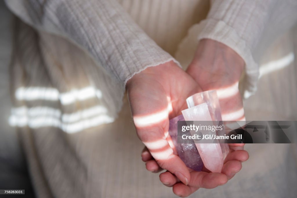 Hands of Caucasian woman holding crystals