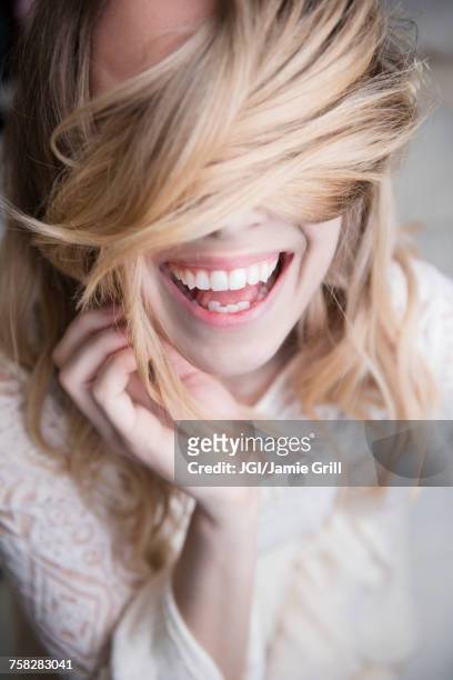laughing caucasian woman covering eyes with hair - hair care stock pictures, royalty-free photos & images