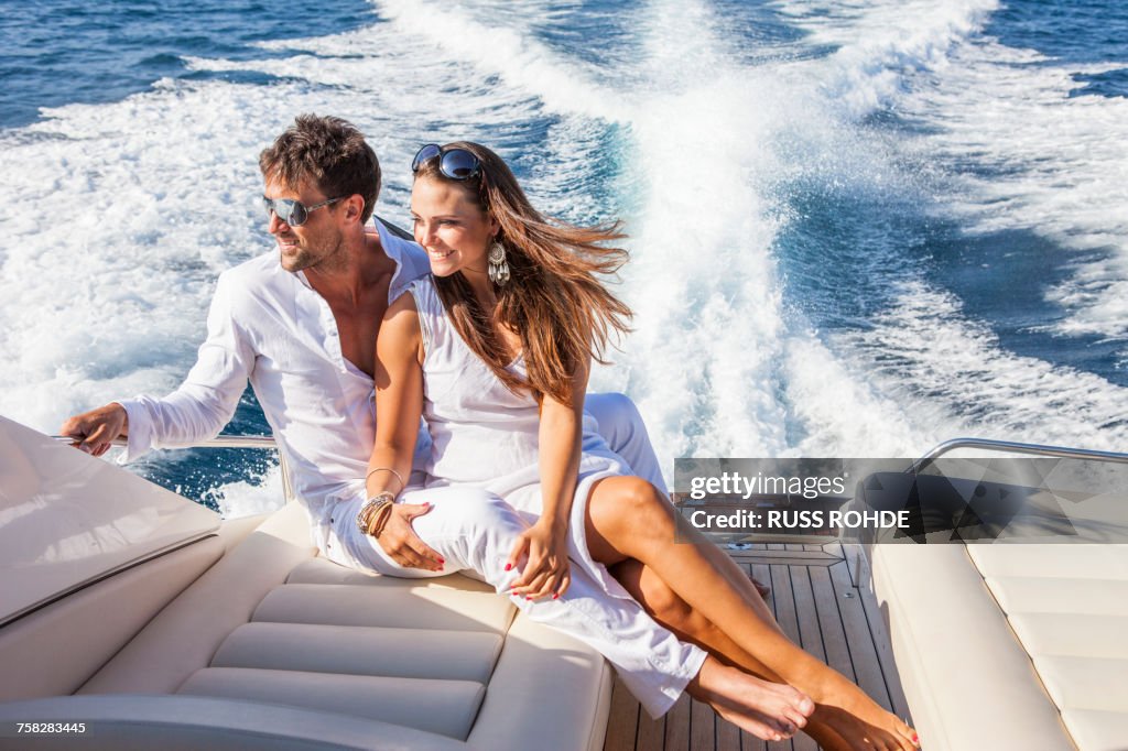 Couple relaxing on yacht, on water, looking at view