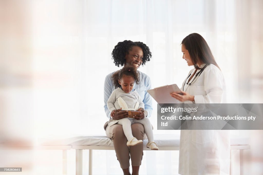 Doctor talking to mother holding daughter in last