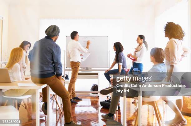 man given presentation at whiteboard in office - black man giving speech stock pictures, royalty-free photos & images