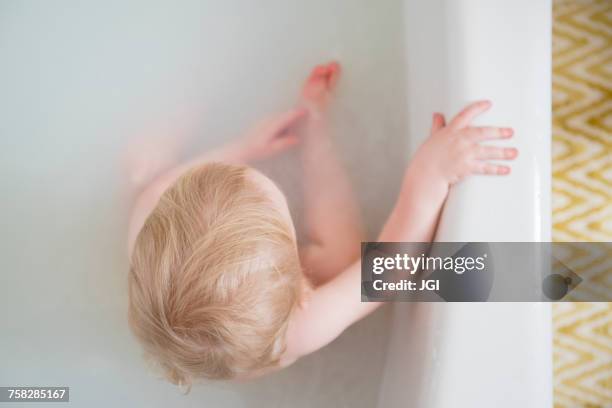 caucasian baby boy in milk bath - milchbad stock-fotos und bilder