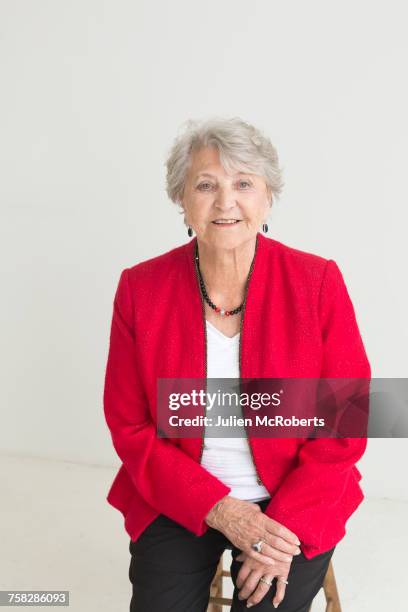 portrait of older caucasian woman sitting on stool - sgabello foto e immagini stock