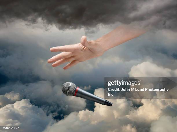 caucasian hand dropping microphone in clouds - reaching the end stock pictures, royalty-free photos & images